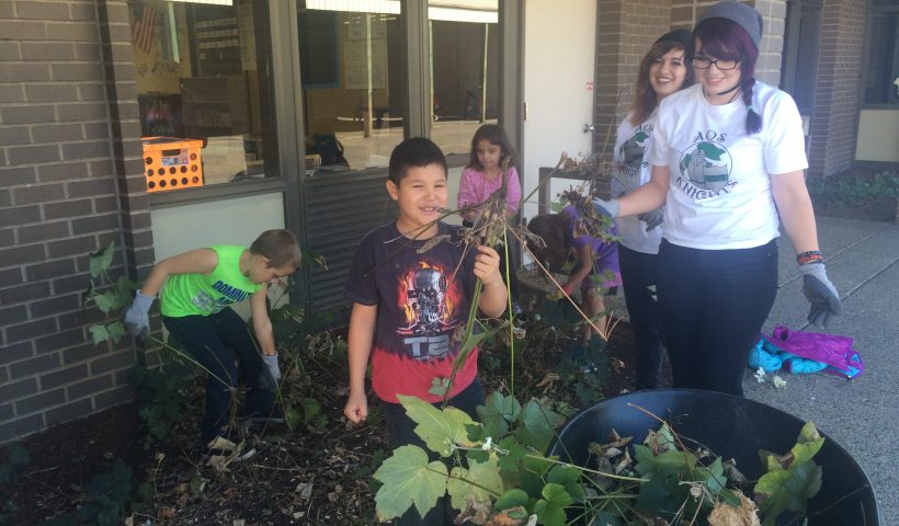 kids planting plants outside school.