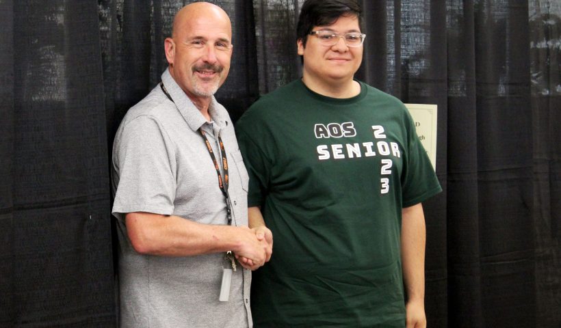 AOS Principal Mark Hannan congratulates AOS Class of 2023 senior Jedidiah Lopez Goodenough.